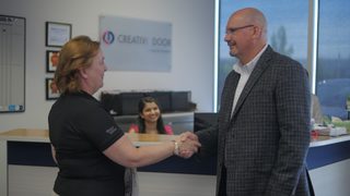 Business client meeting with Creative Door Services team at the office reception desk