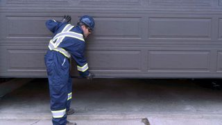CDS technician inspecting garage door weatherstripping