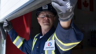 CDS technician inspecting sectional steel door weatherstripping