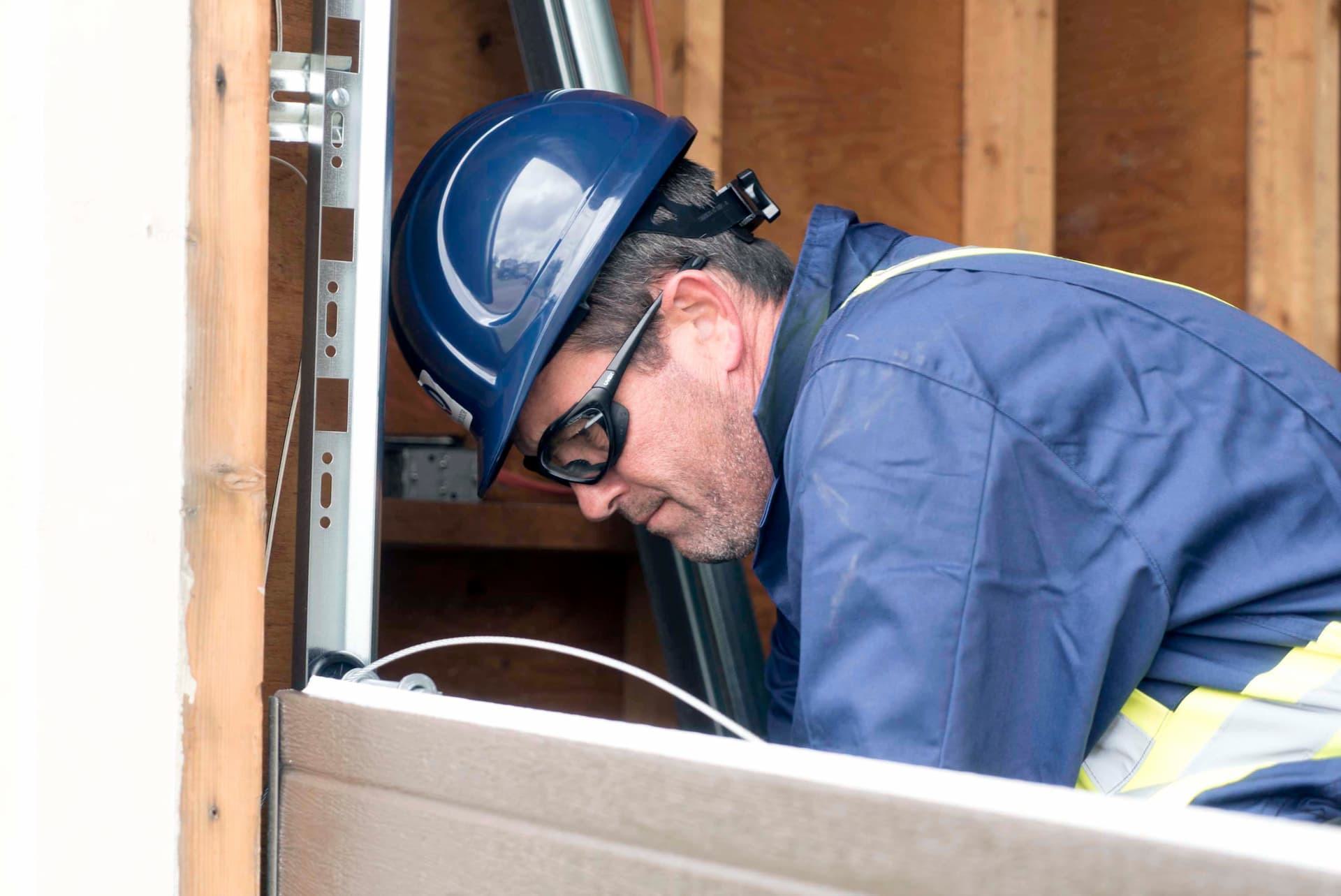 Creative Door Services technician installing garage door cable