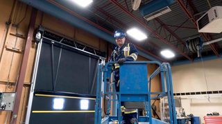 CDS technician on forklift servicing high performance door for heavy industrial facility