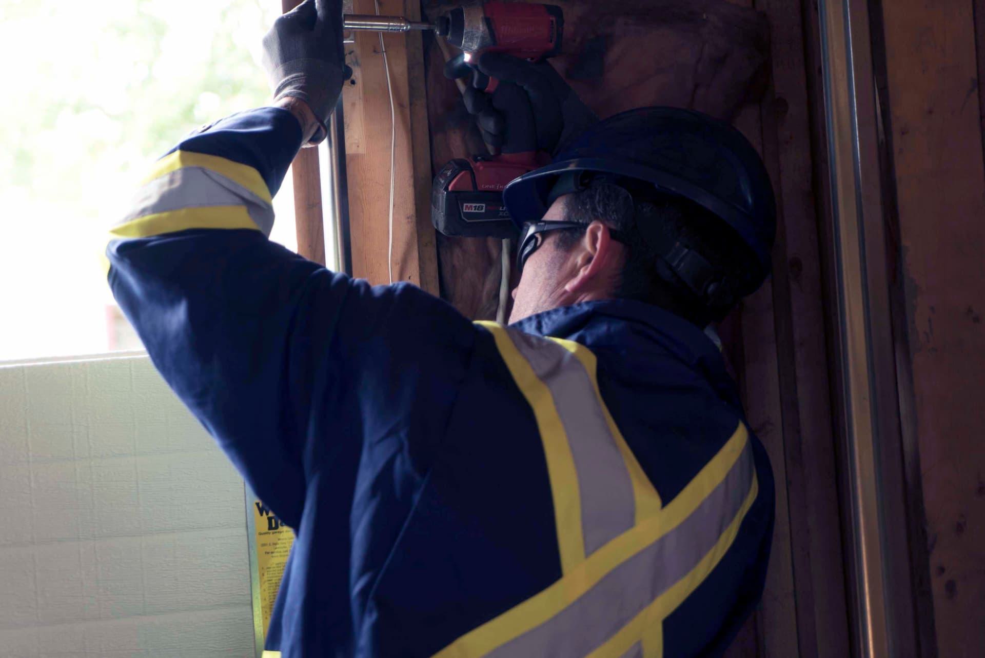 Creative Door Services technician safely installing garage door cable