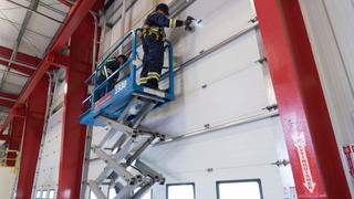 CDS technicians on forklift repairing commercial sectional door