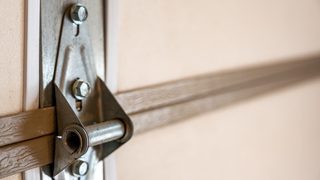 Closeup of garage door metal hinge on panels