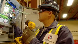 Creative Door Services technician inspecting commercial door controls