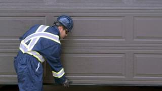Creative Door Technician Assessing Garage Door