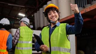 Female Technician In Warehouse Thumbs Up Min