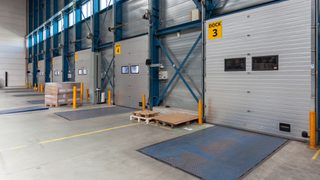 Numbered loading docks in a warehouse with mechanical pit levelers