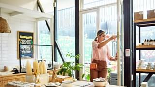 Young business owner unlocking front door of retail shop