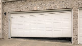 Broken garage door damaged by vehicle collision