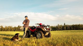 Man In Field With Atv And Dog Min