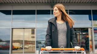 Shopper with grocery cart exiting mall with automatic doors