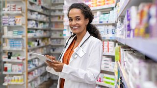 Smiling Pharmacist Doing Inventory Min