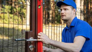 Technician checking level of gate post