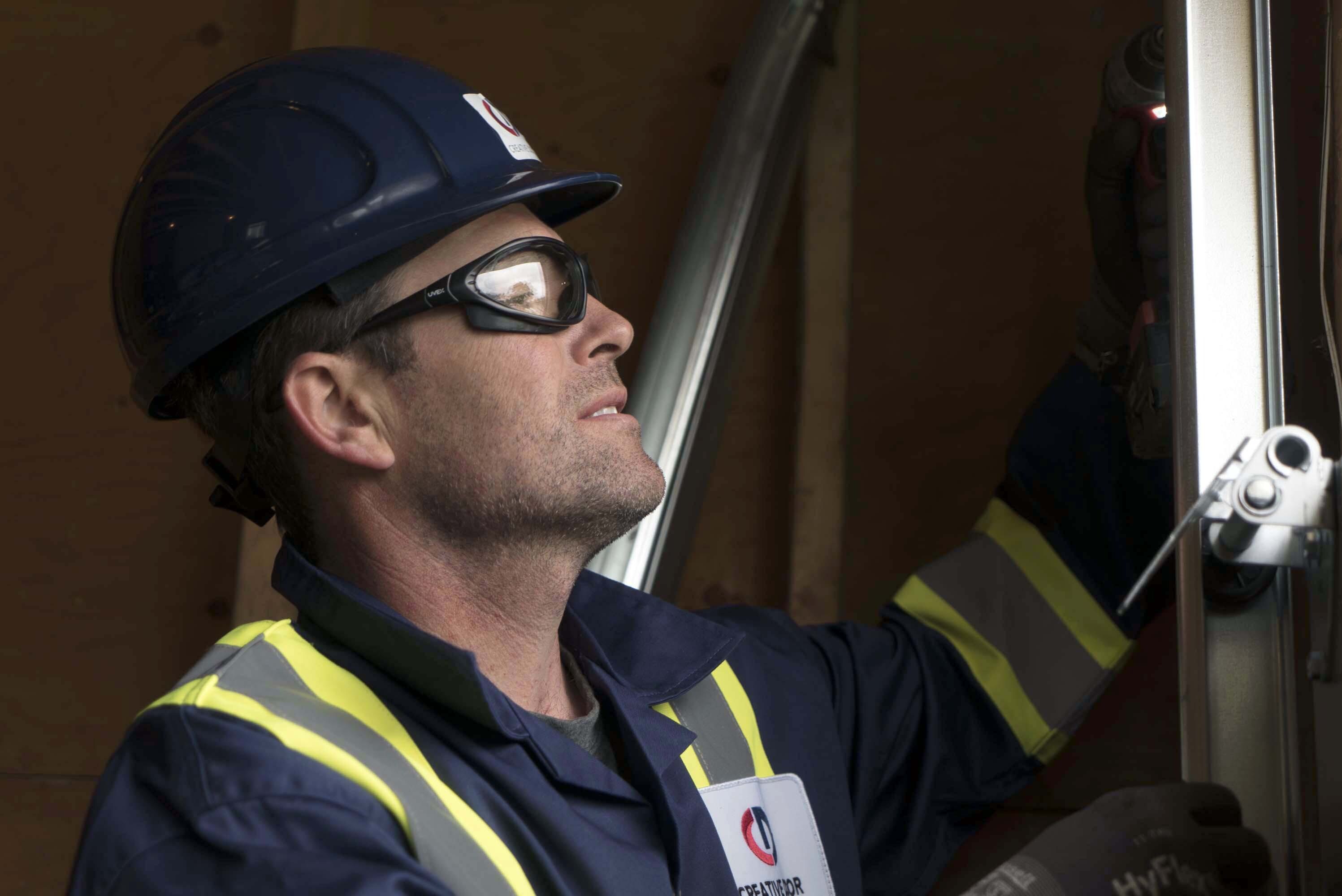 closeup of a Creative Door Services technician installing rear track hangers