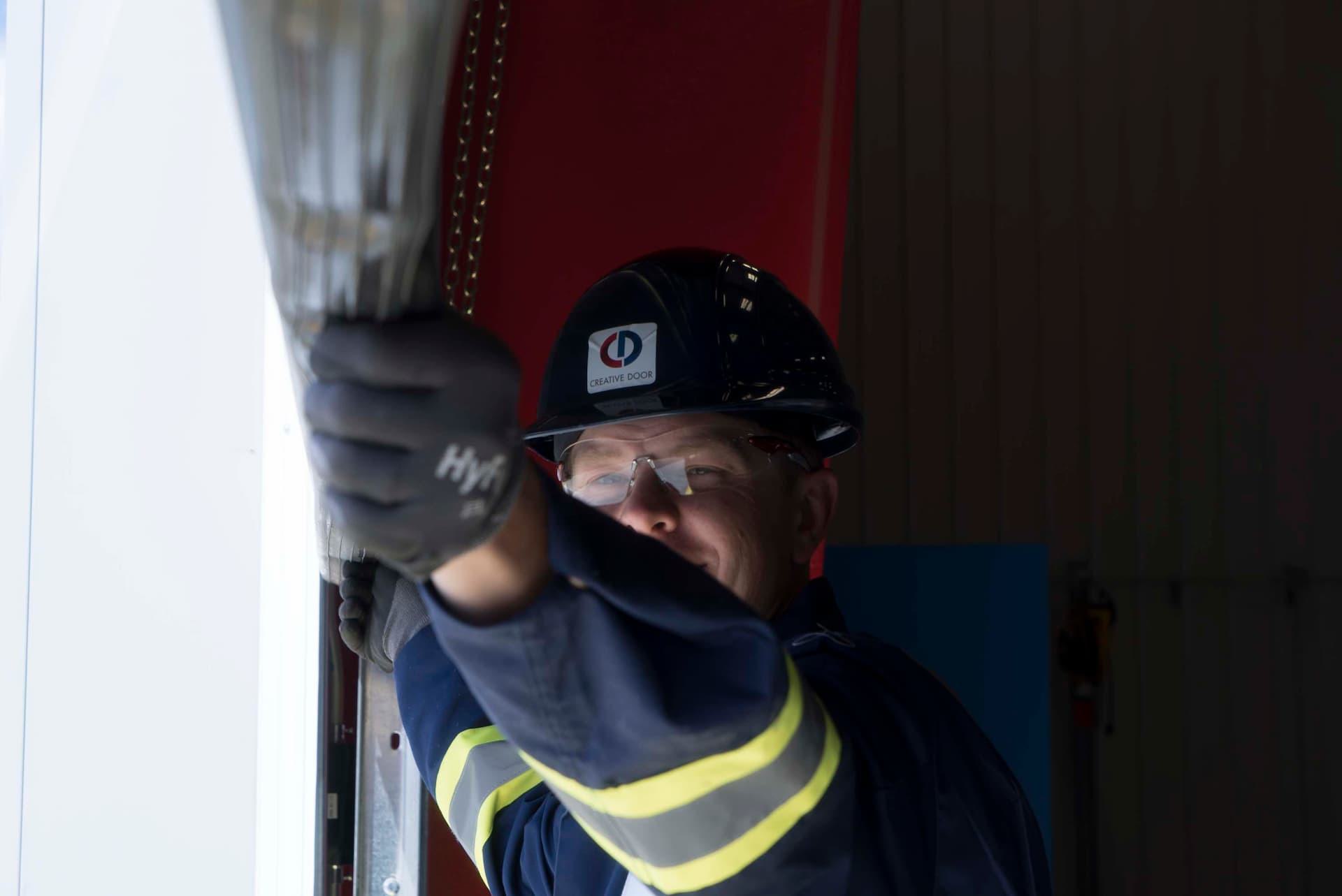 Creative Door Services technician checking door weatherstripping