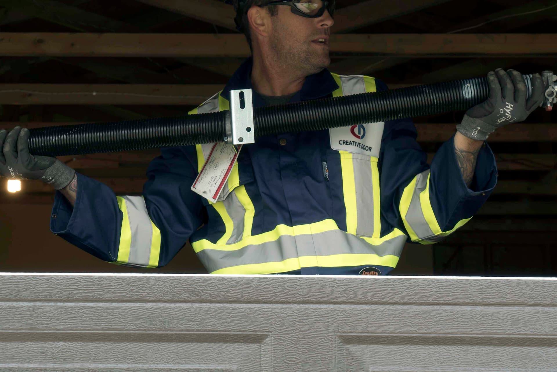 Creative Door technician holding new garage door spring