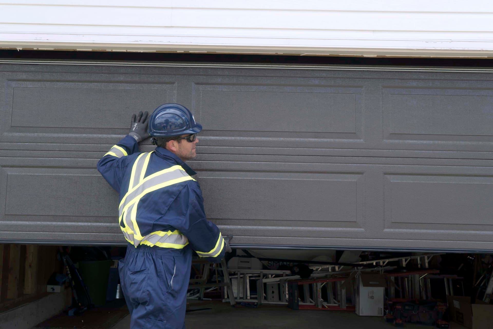 Creative Door Services technician inspecting and testing garage door