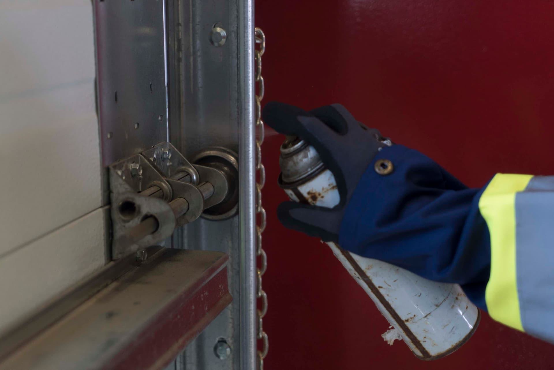 Creative Door Services technician lubricating pedestrian door
