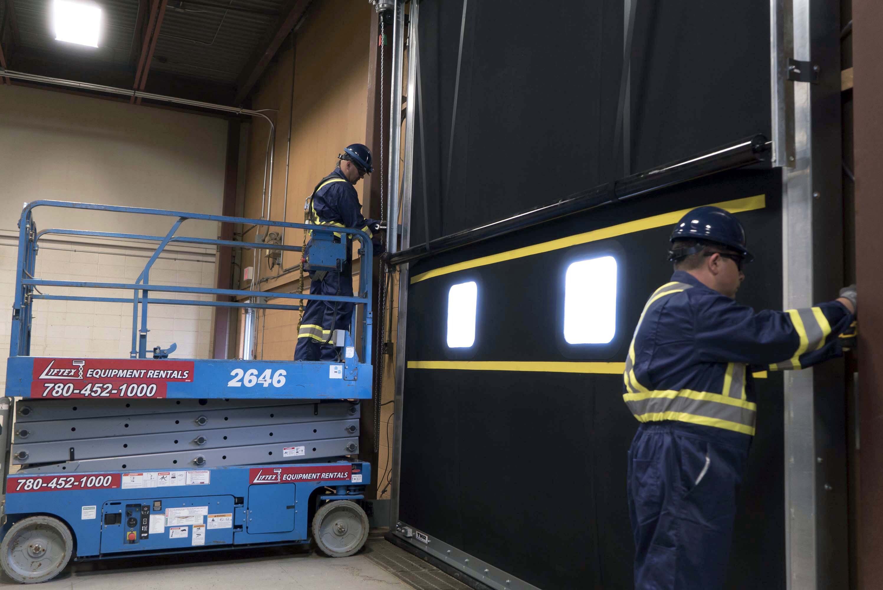 Creative Door Services technician maintaining commercial sectional door