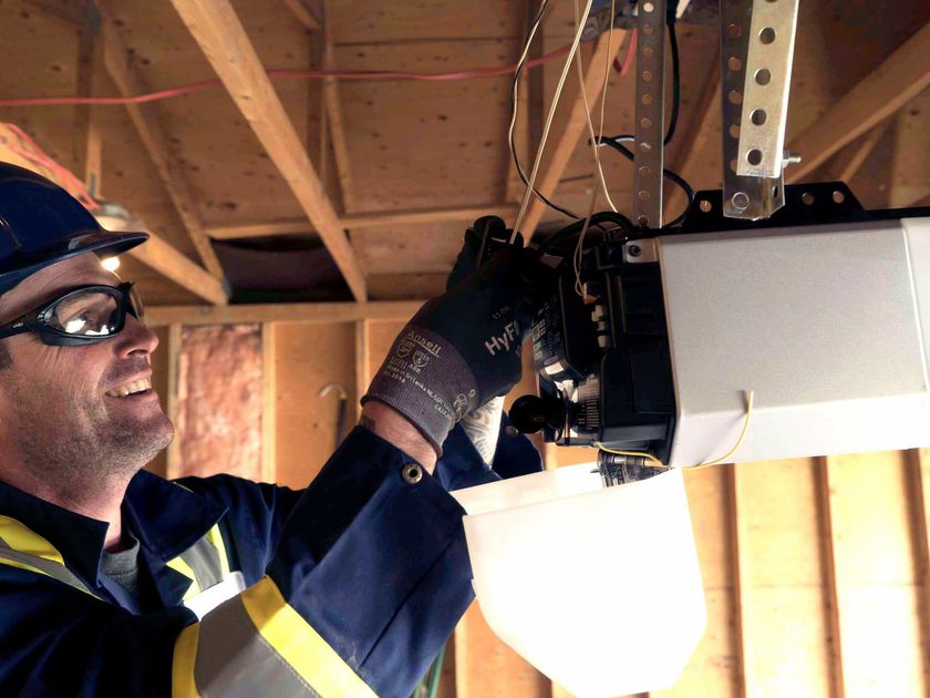 Creative Door Services technician repairing garage door opener