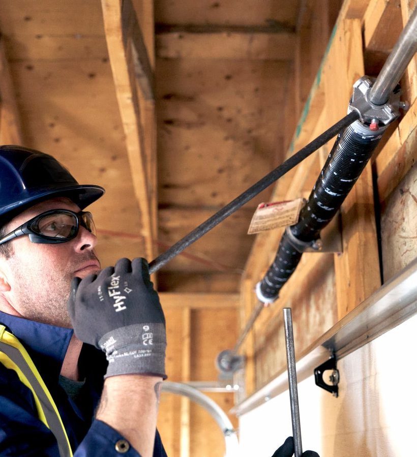 CDS technician servicing garage door spring
