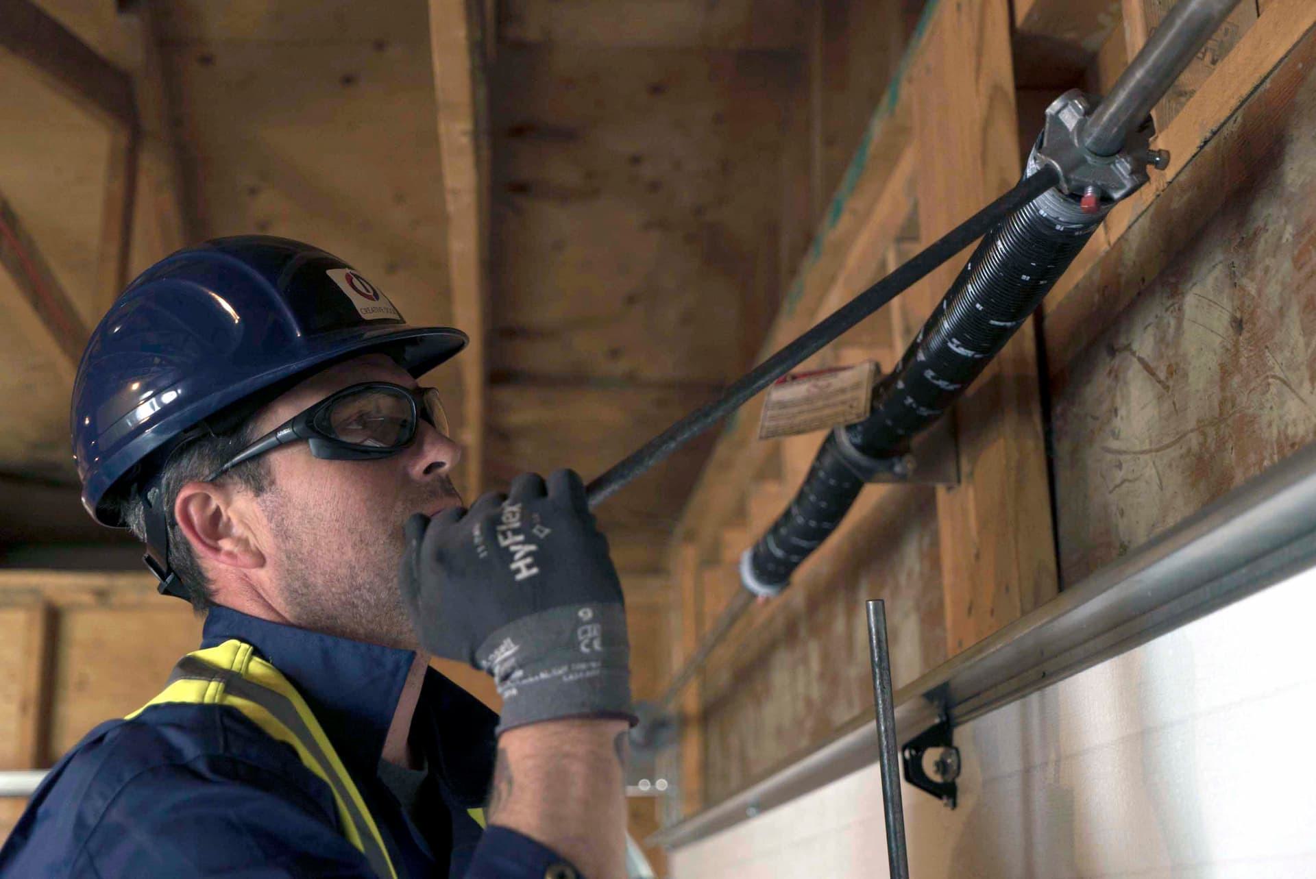 CDS technician tuning garage door spring