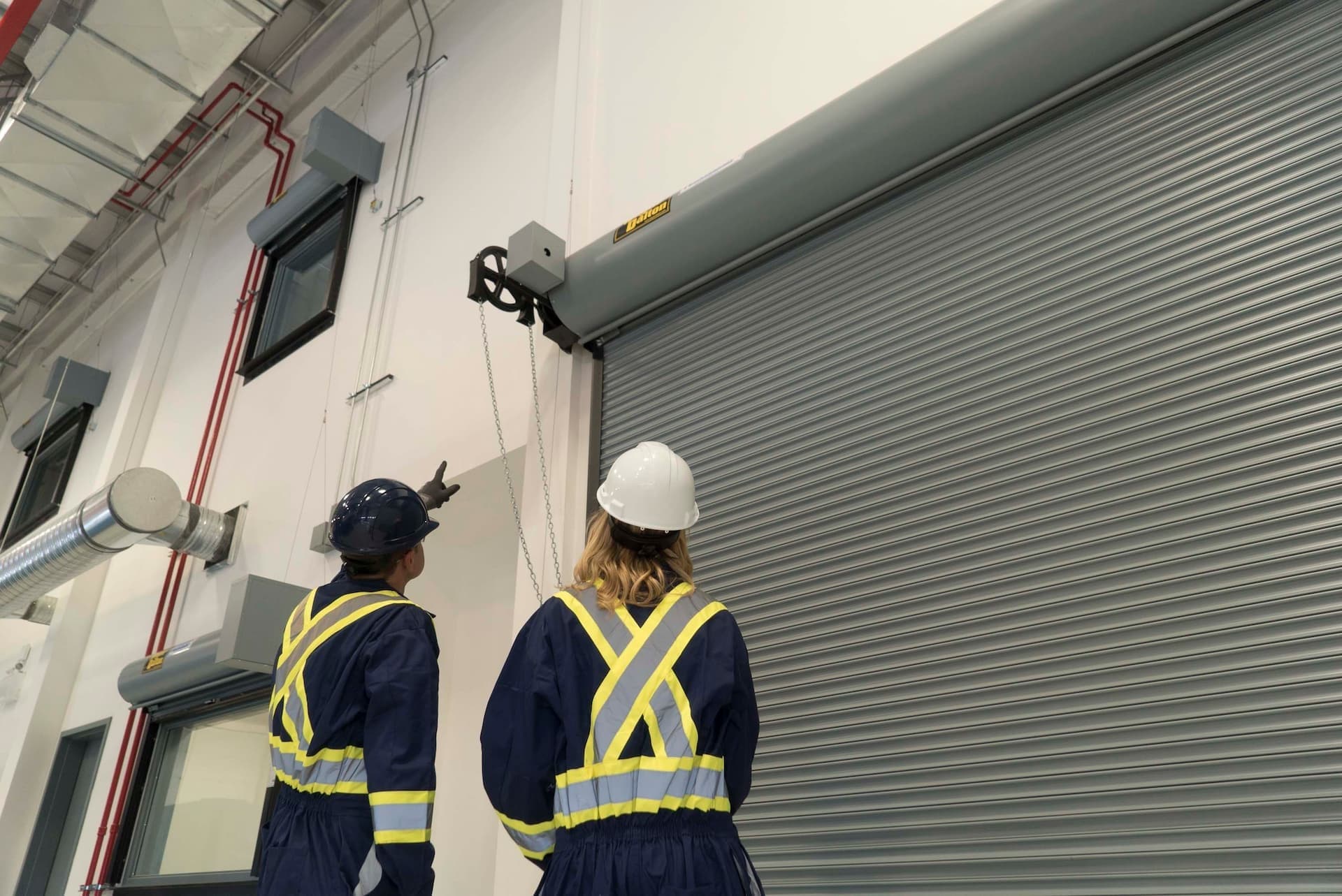 Creative Door Services technicians inspecting commercial rolling door