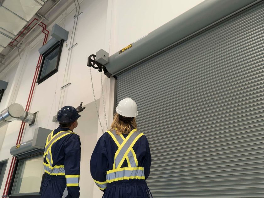 Creative Door Services technicians inspecting rolling steel doors