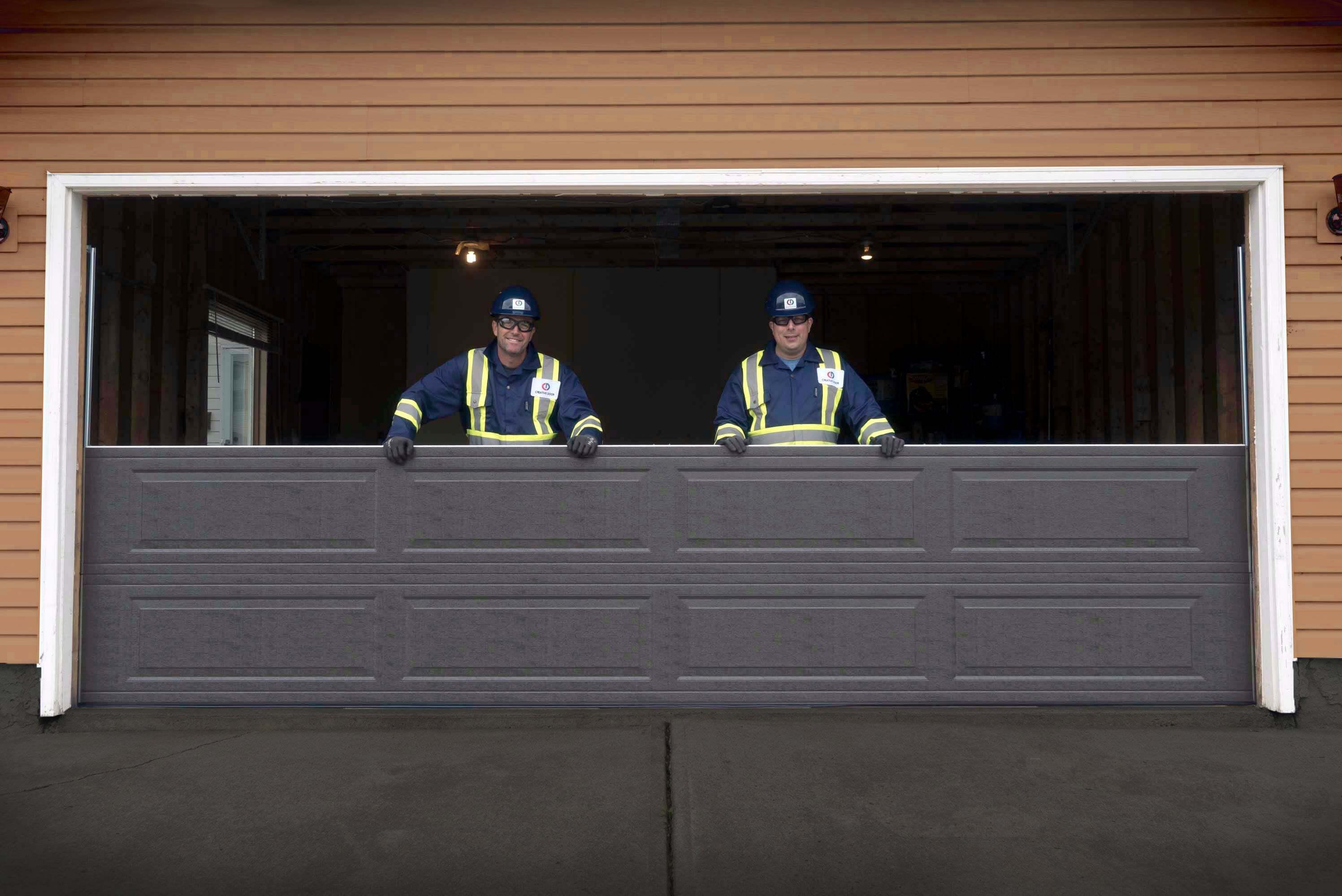 Creative Door Services technicians installing a new garage door