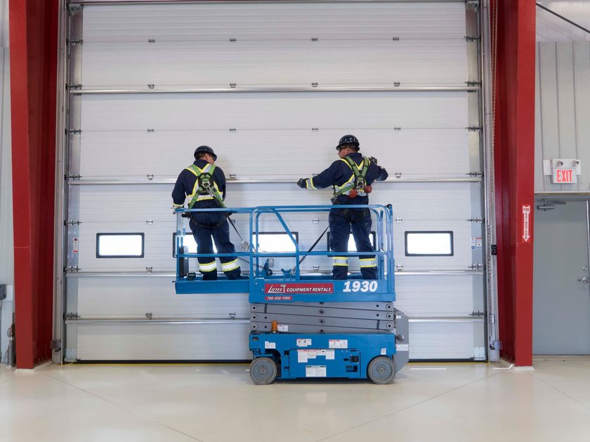 Creative Door Services technicians installing commercial sectional door