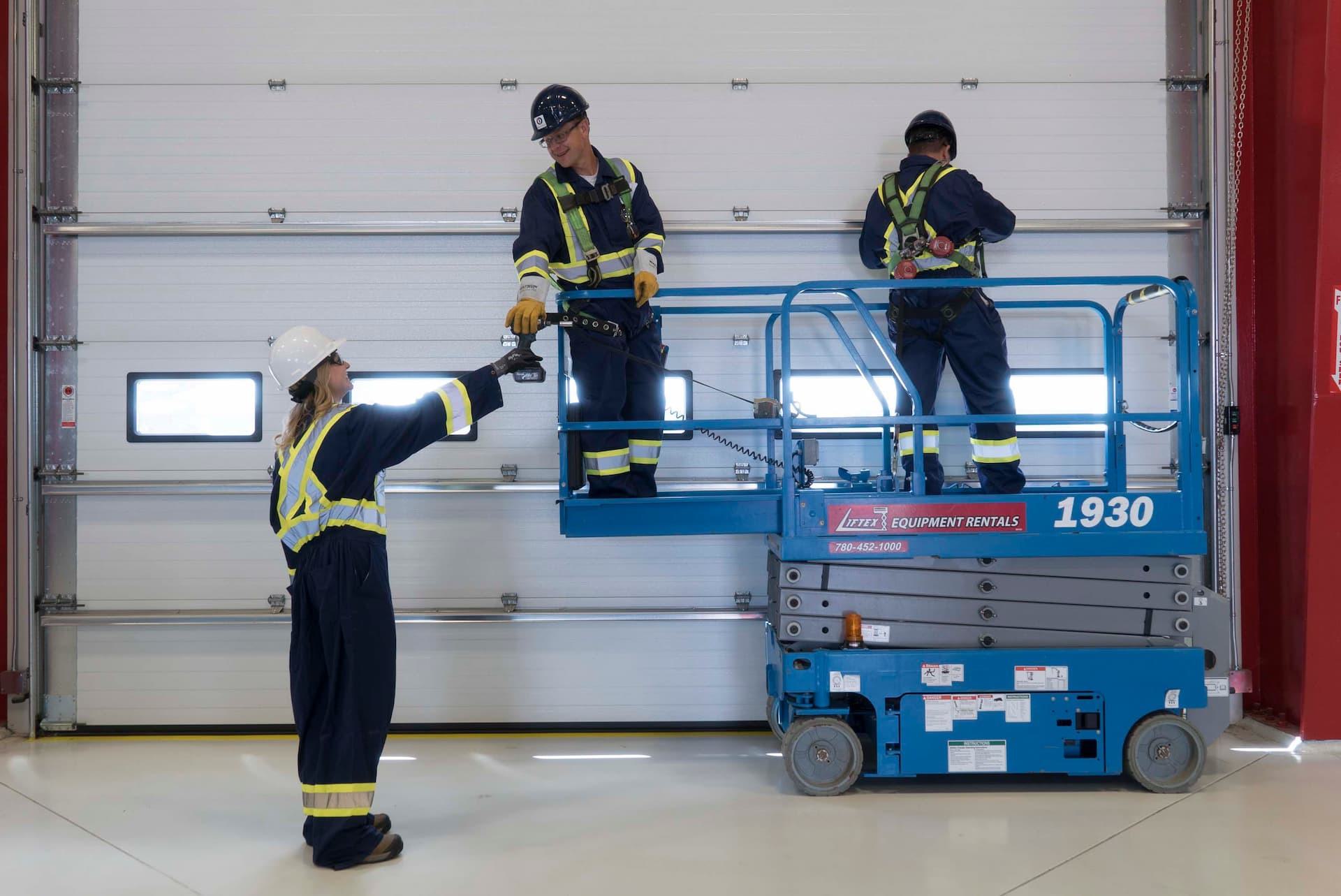 Creative Door Services technicians servicing commercial sectional door