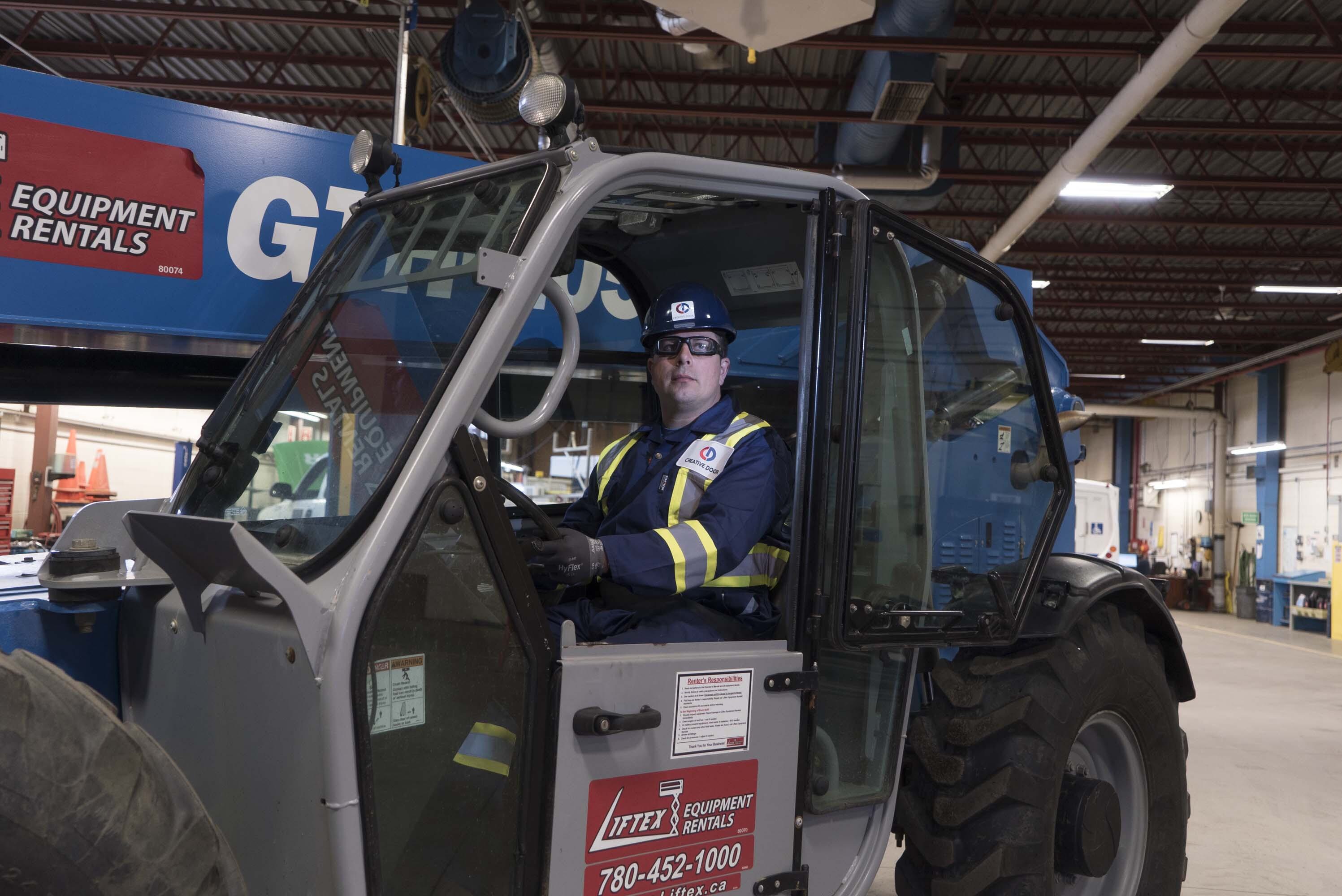 Creative Door Services maintenance technician driving a forklift