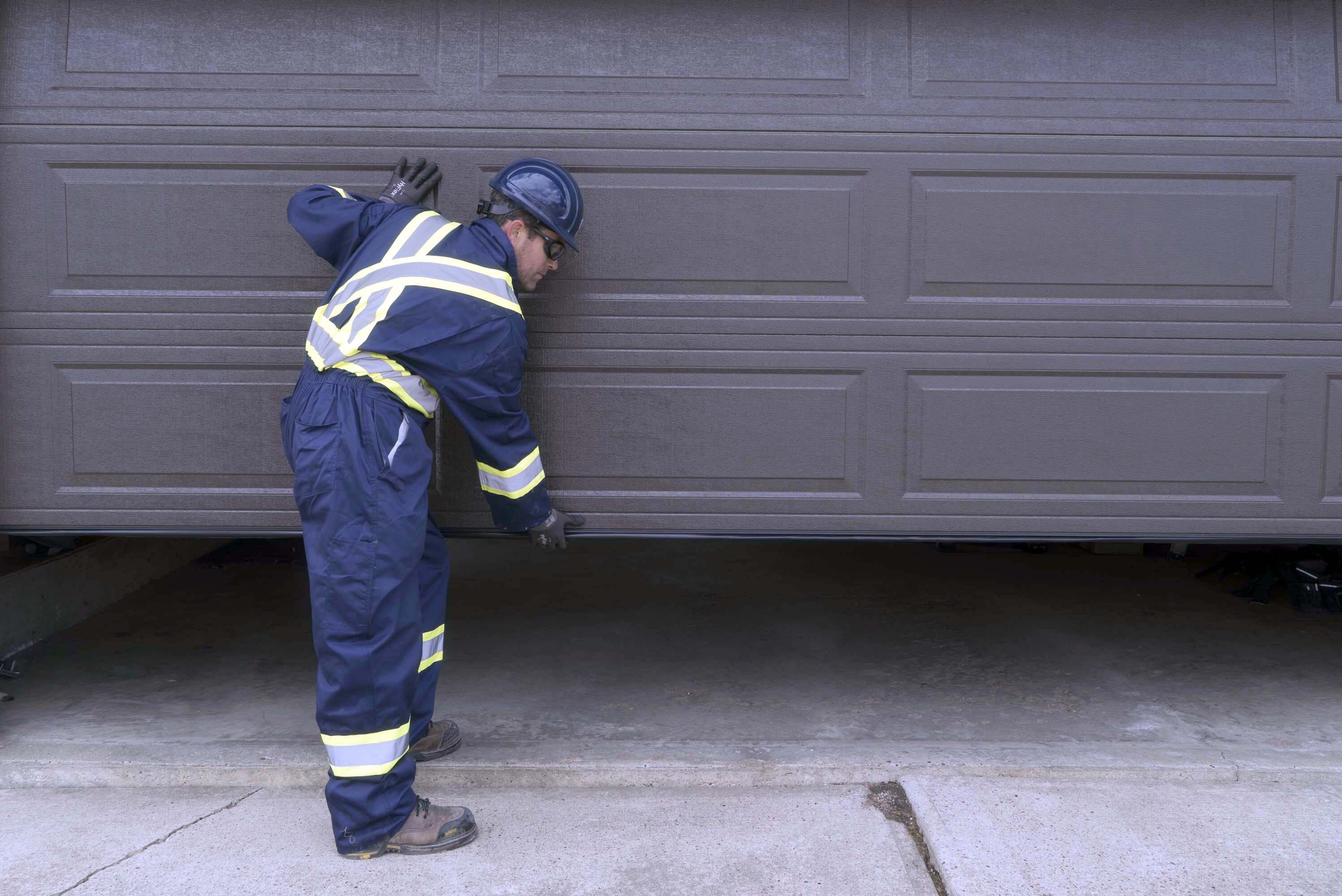 Creative Door Services technician repairing garage door that won't close