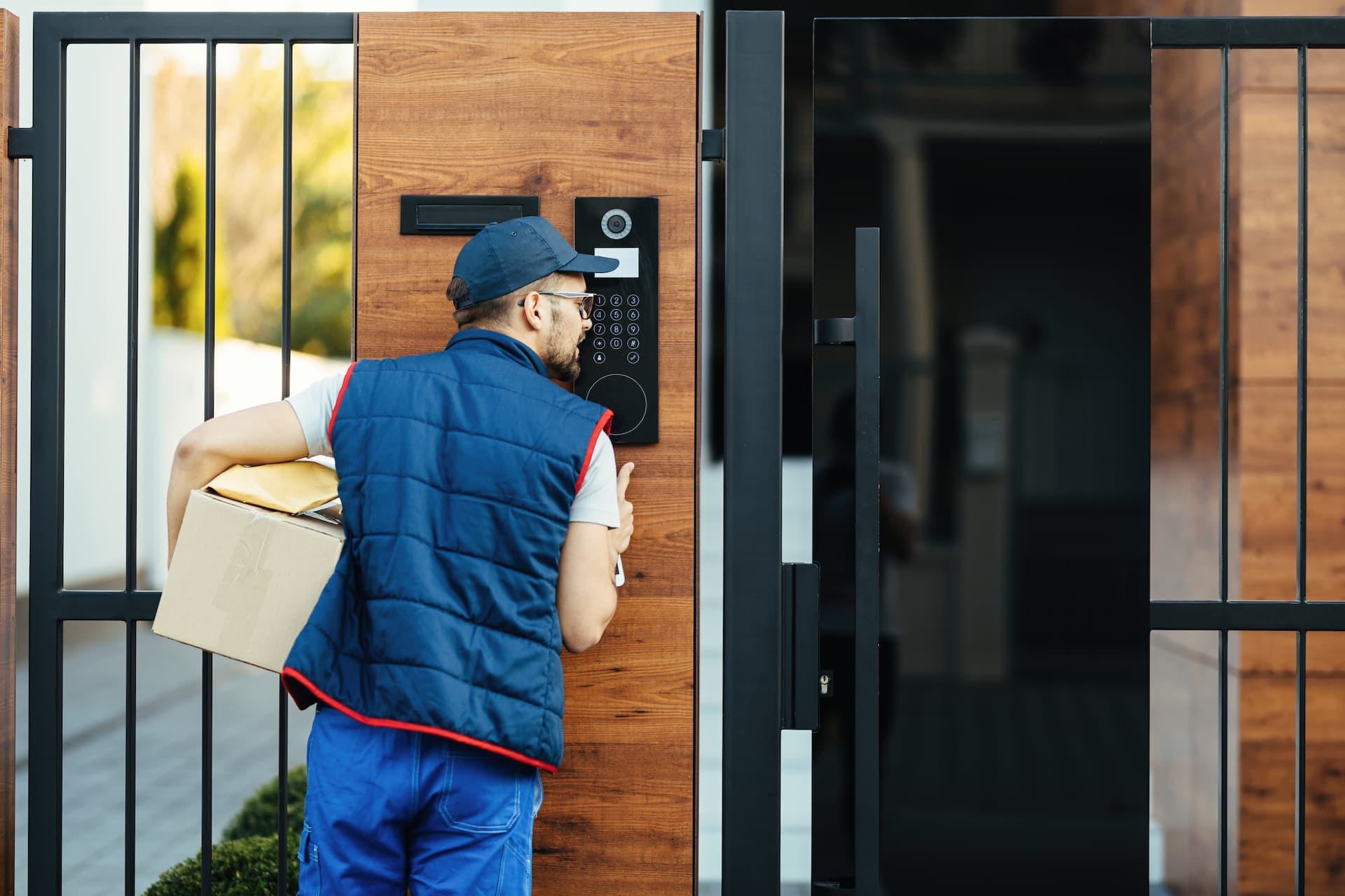 Delivery driver using a video intercom system at a residential gate to request secure entry