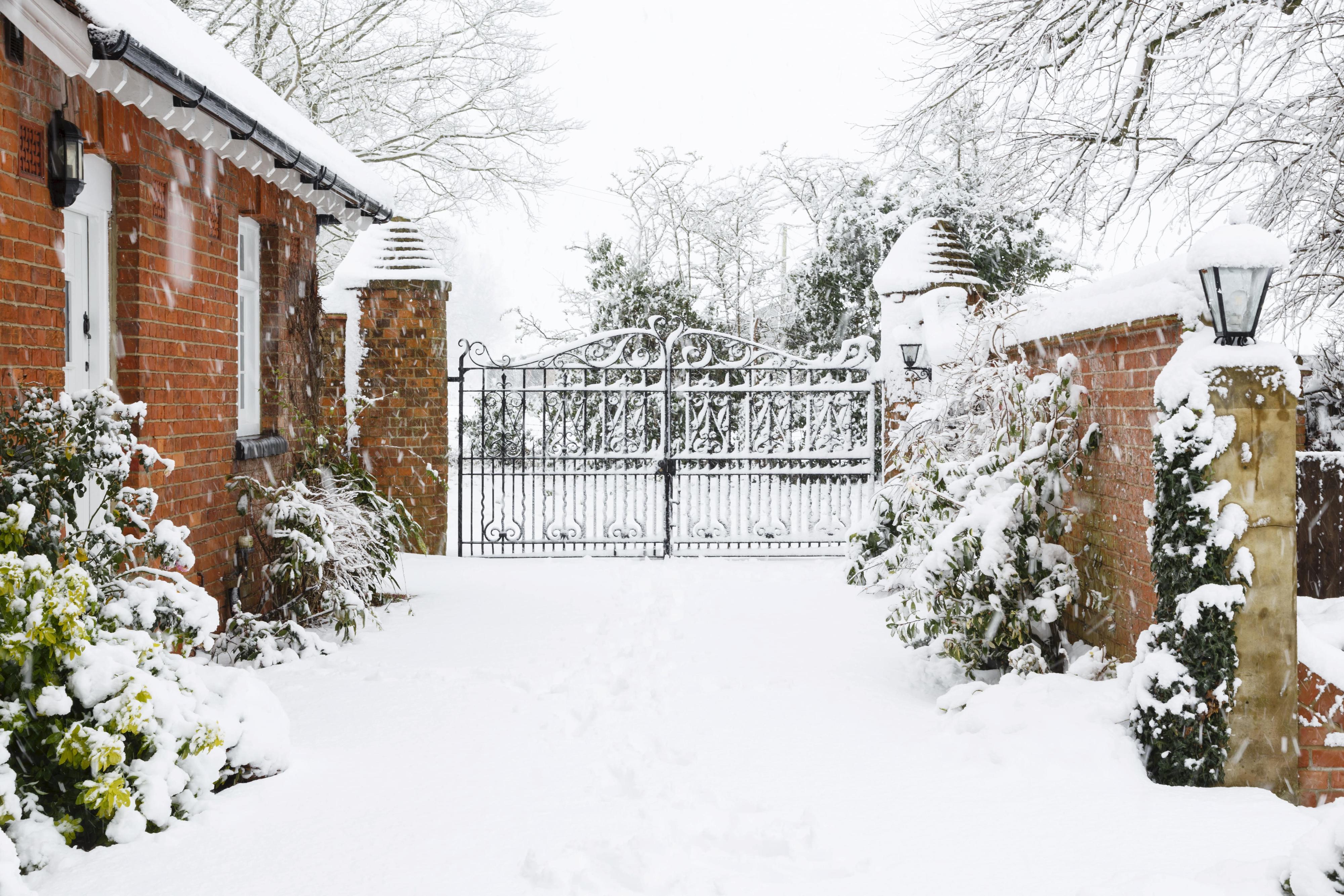 Driveway to a rural house with an automatic gate in the winter