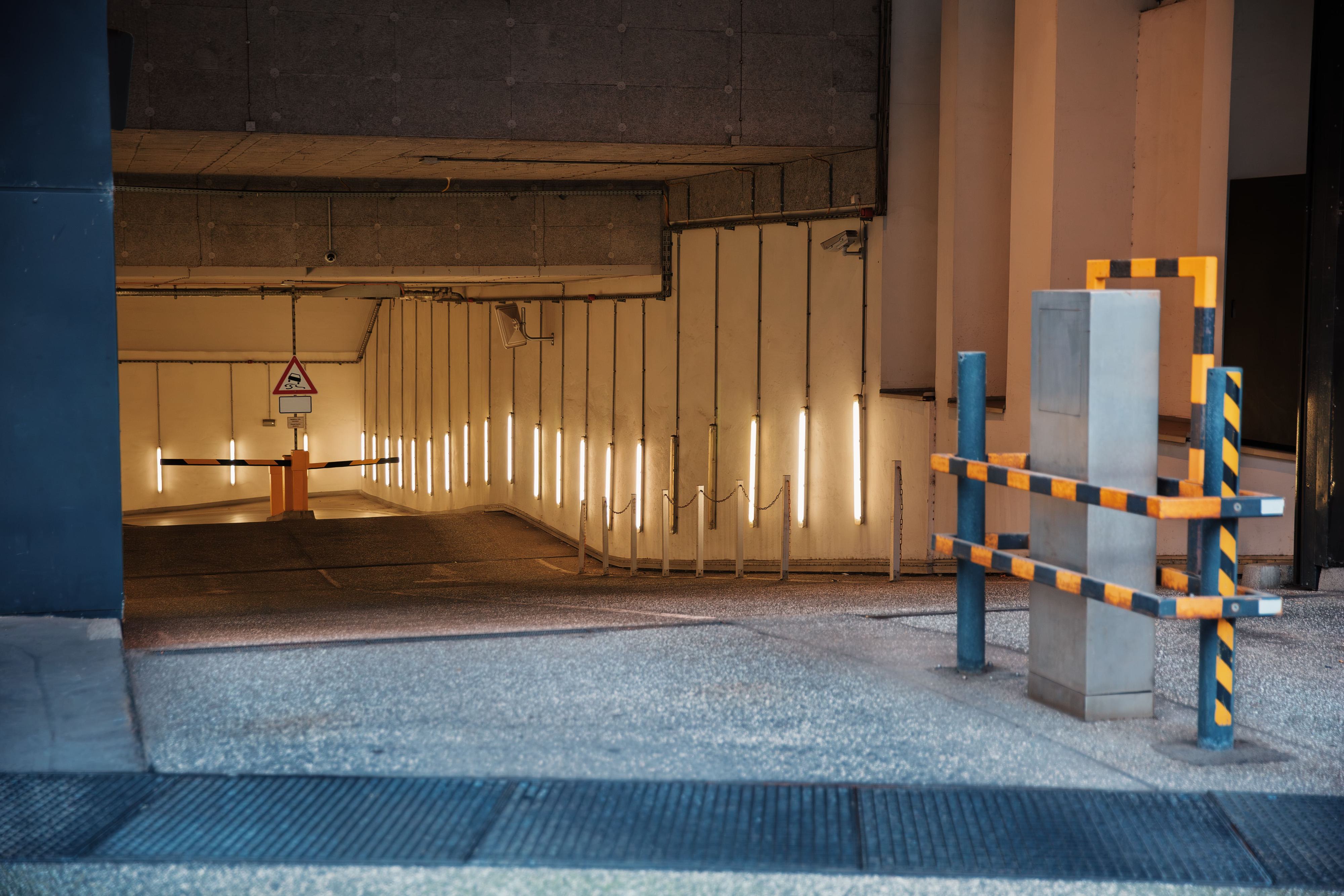 entering illuminated underground parking garage with security barrier