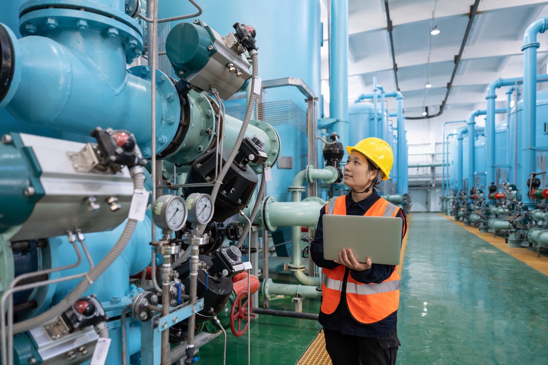 Industrial worker checking pipelines inside refinery