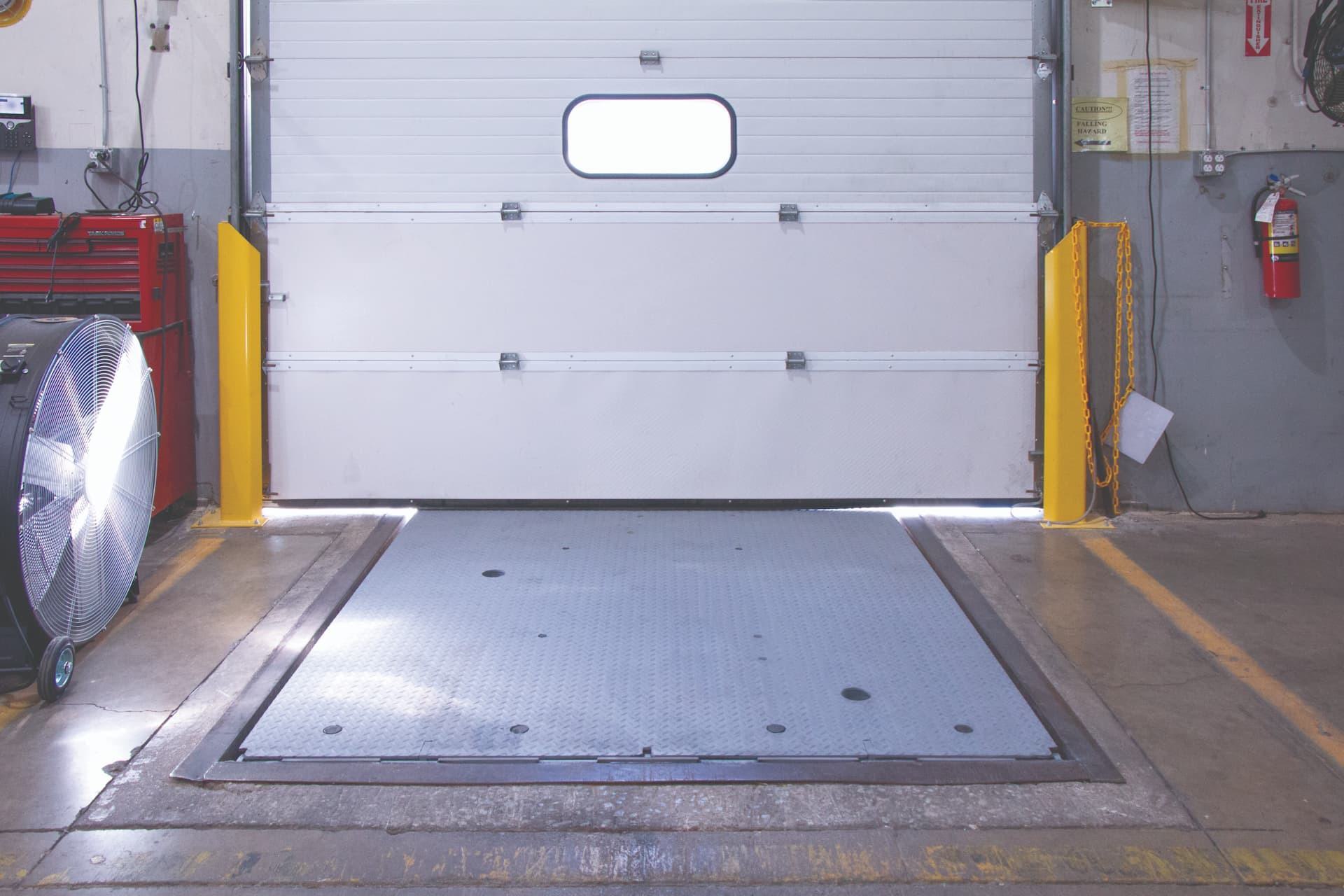 Loading dock entrance with mechanical pit leveler