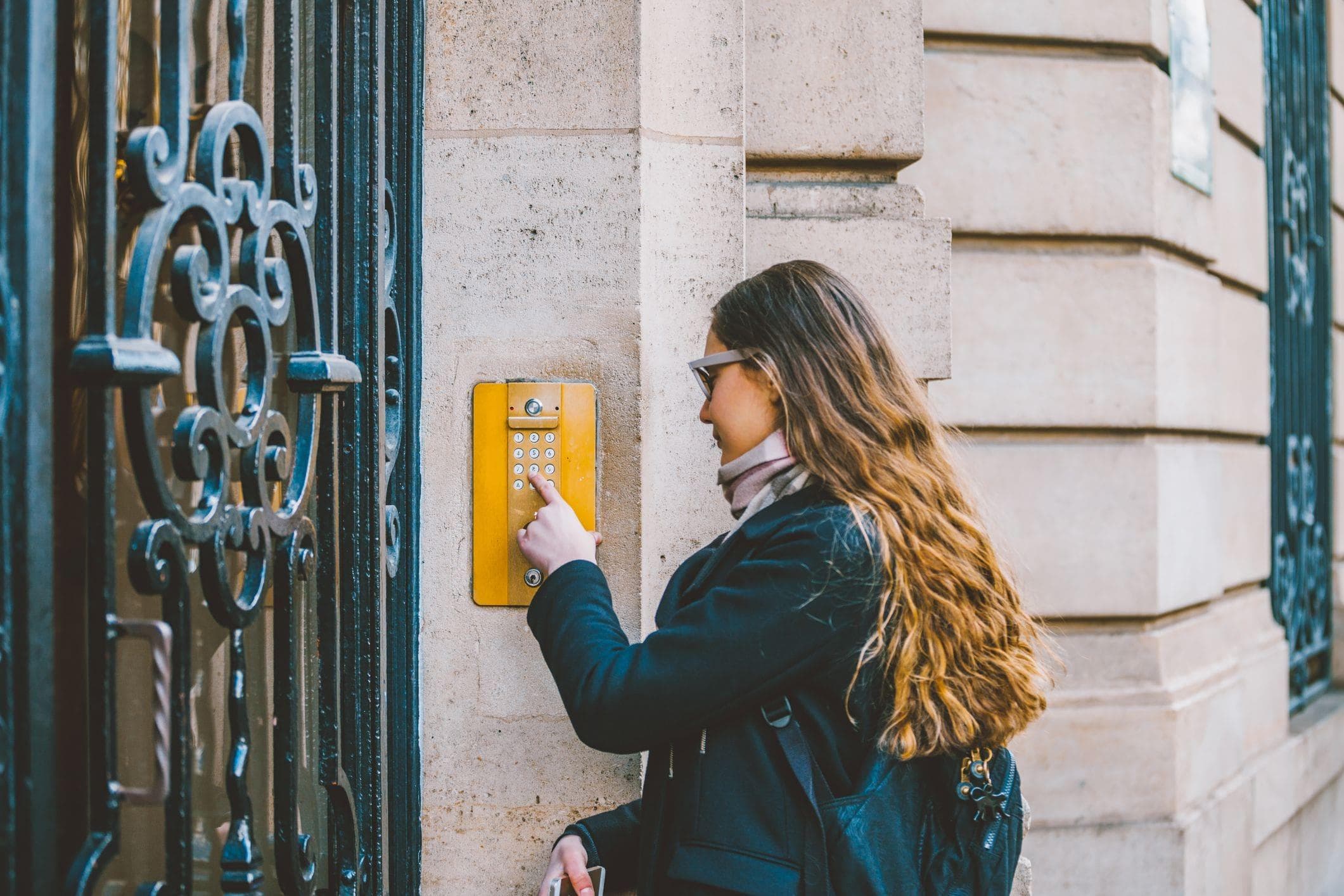 woman using a keypad to gain access to her residential apartment building
