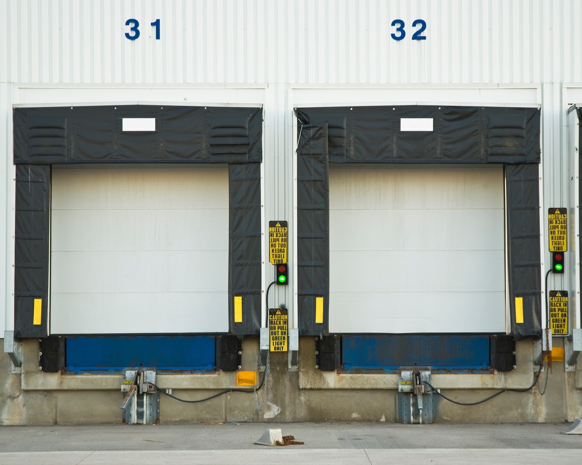 Two loading dock doors with dock seals and signal lights