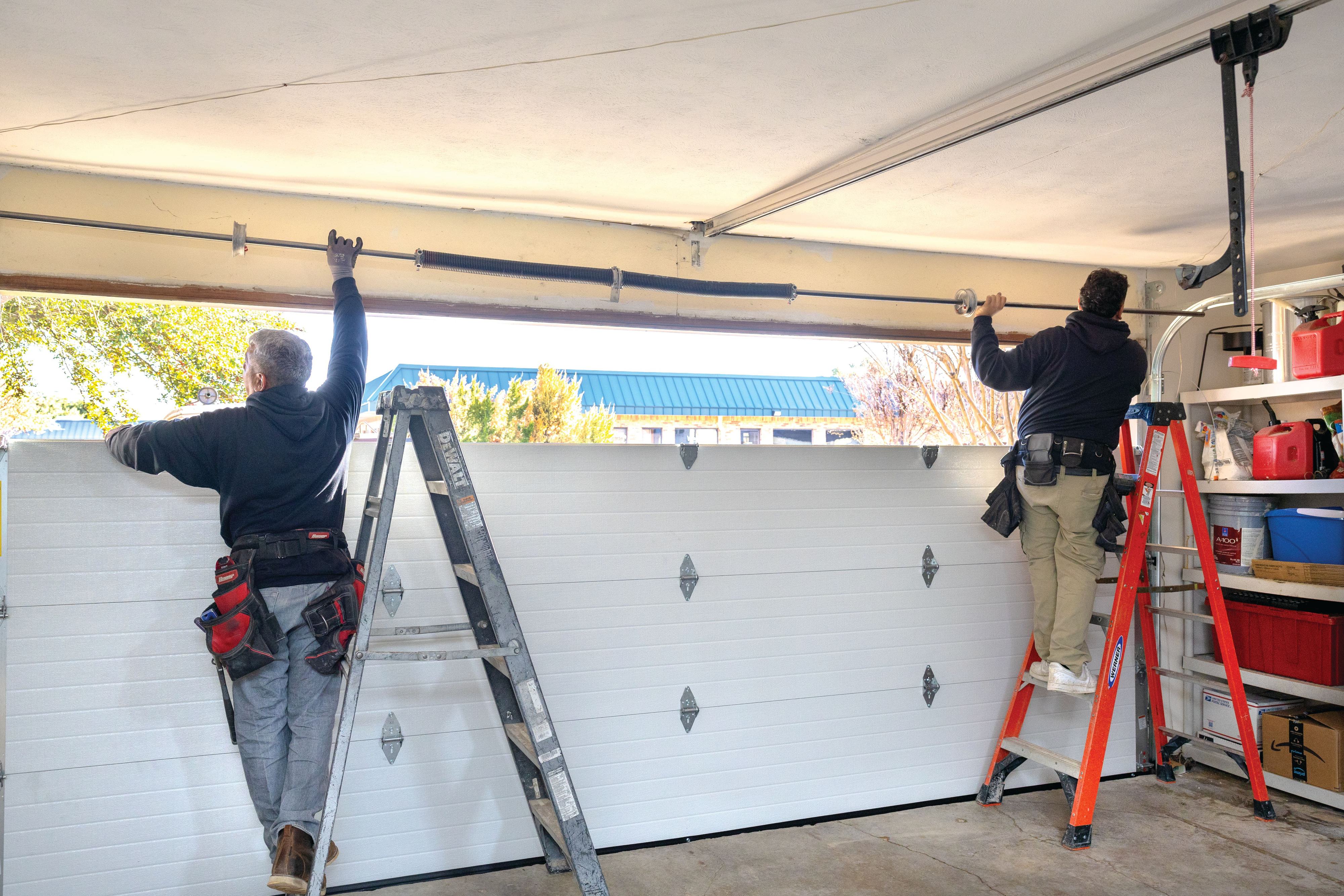 technicians inspecting and installing a wayne dalton white garage door