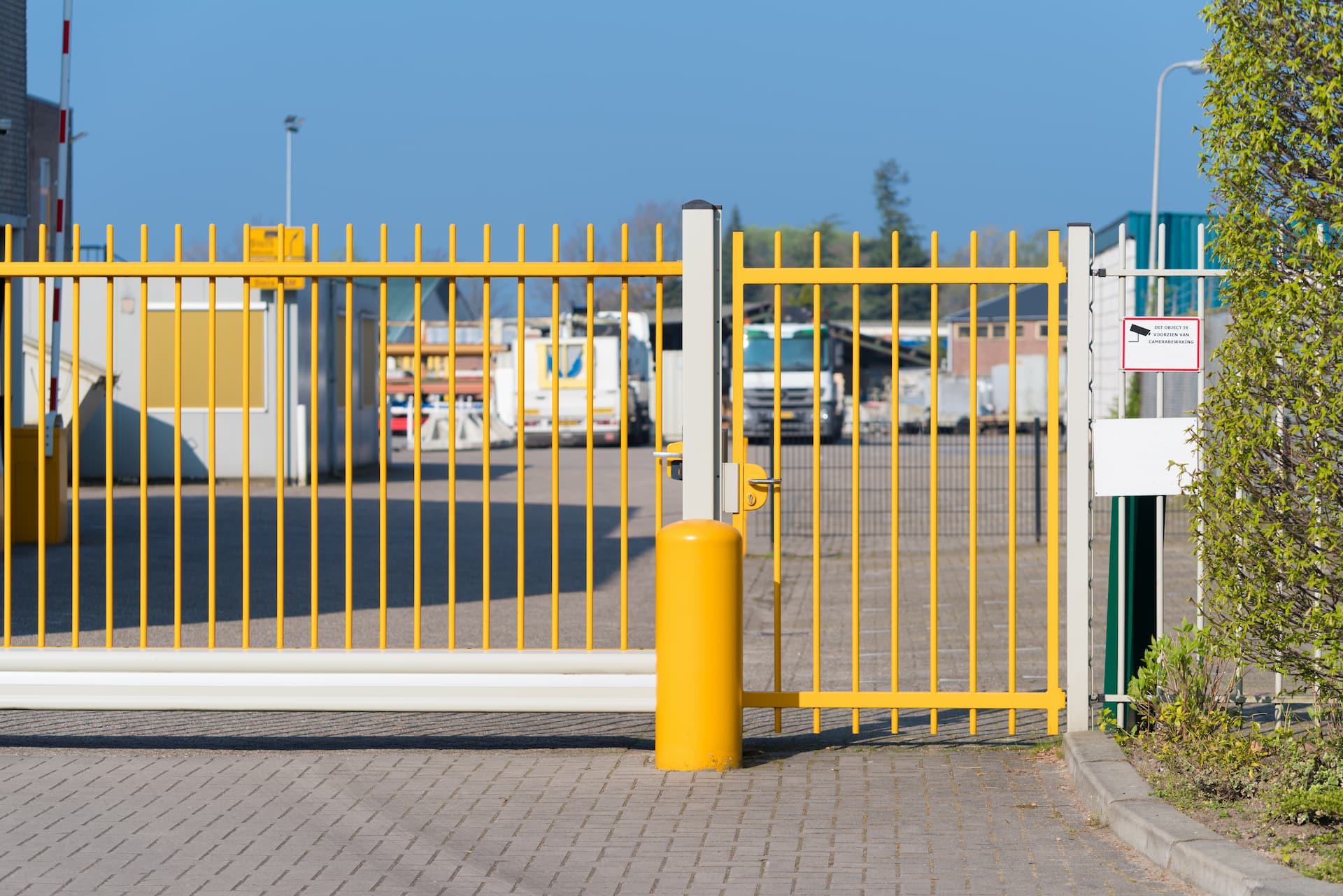 yellow metal gate with pedestrian access