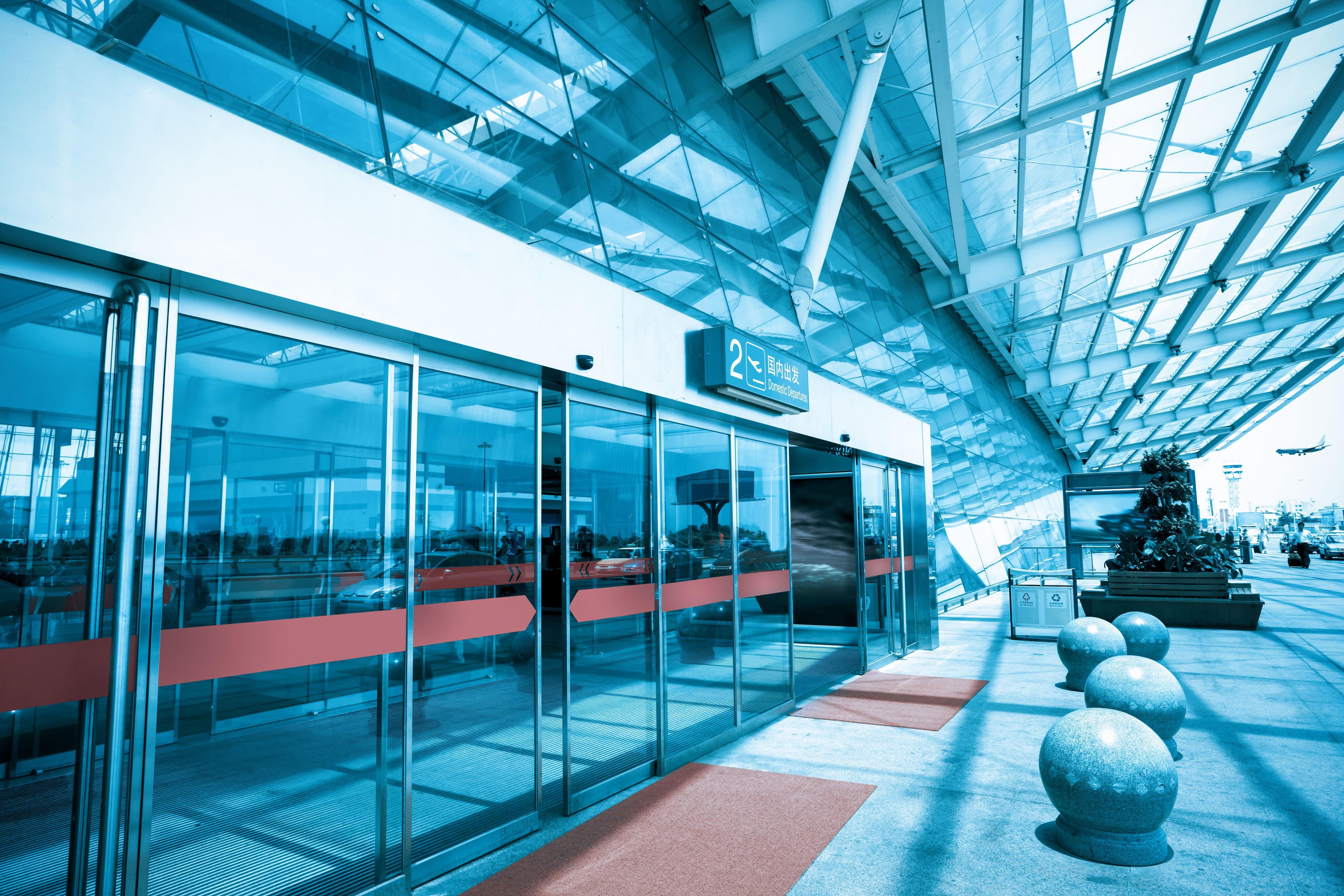 airport entrance to terminal with glass automatic pedestrian doors