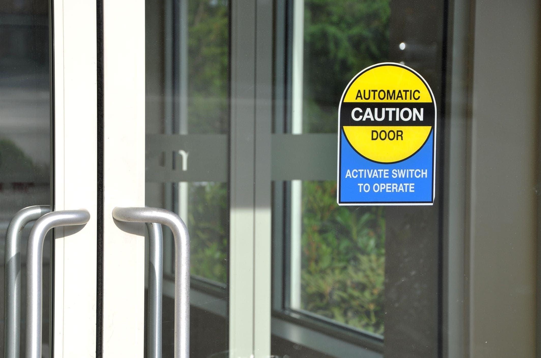 glass automatic door with caution sign
