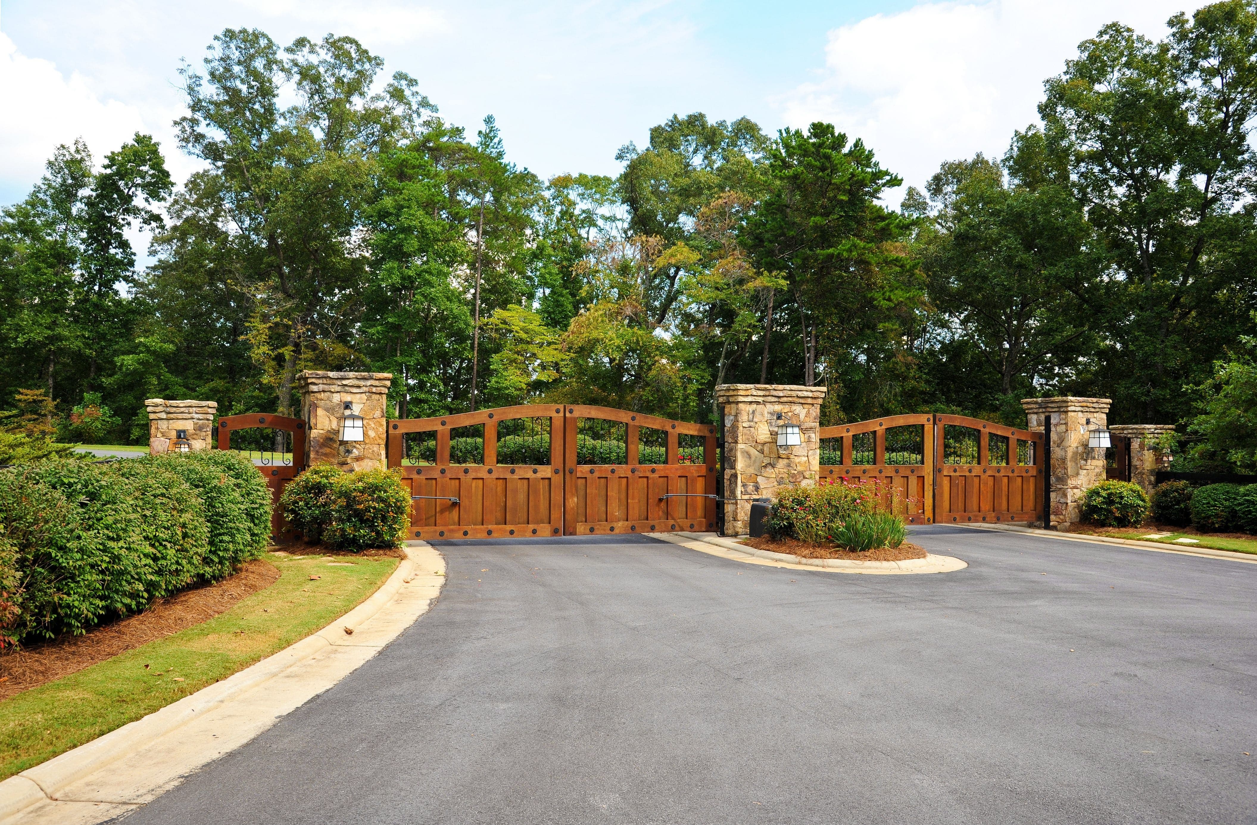beautiful wood gates at the end of a long driveway