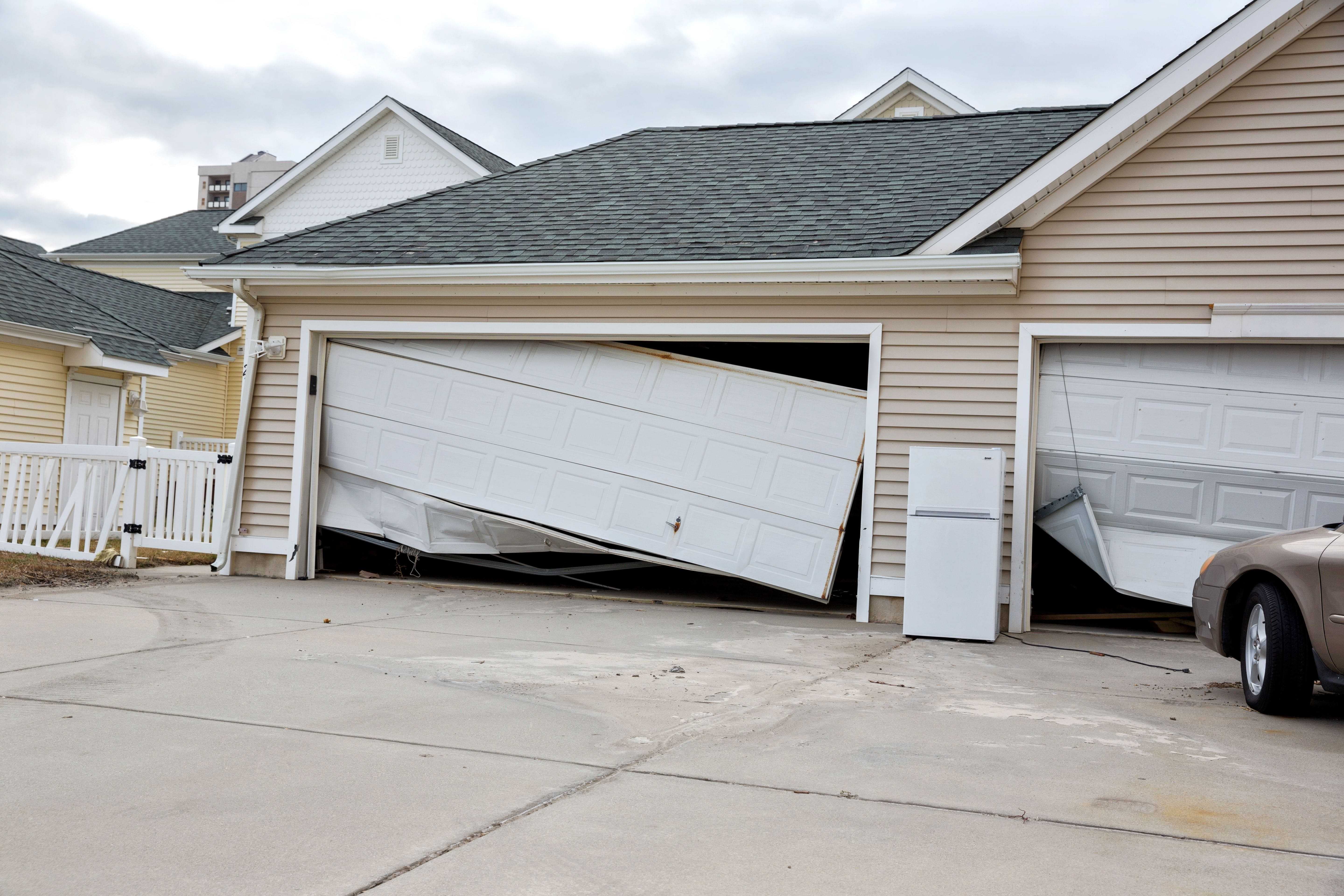extremely bent garage doors after extreme wind storm