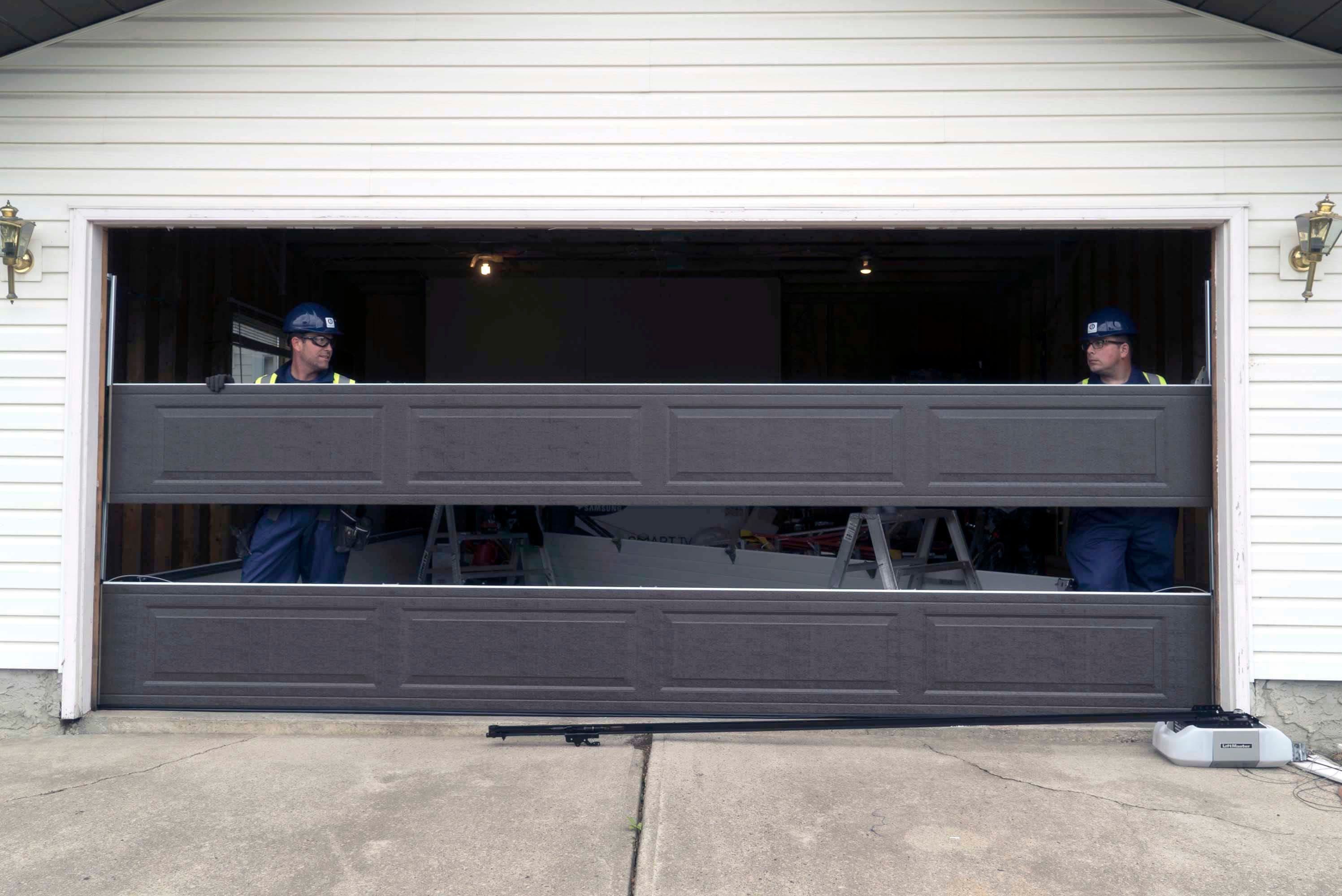 two cds technicians repairing and fixing a garage door