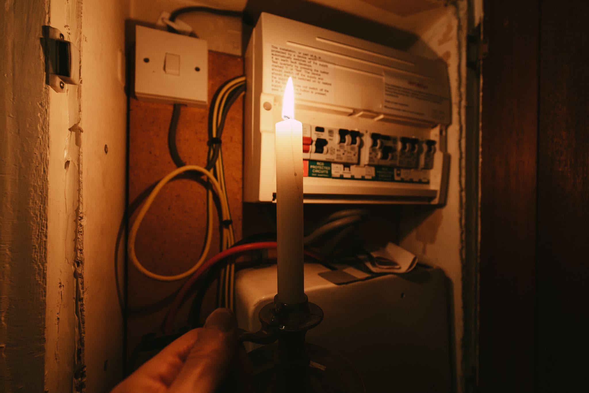 man stuck inside garage using candle to view power control panel