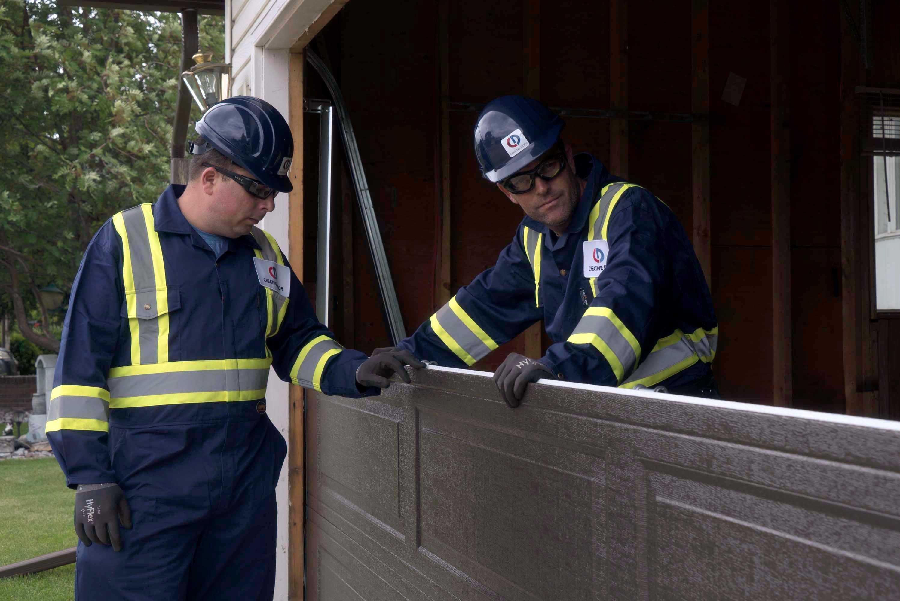 two creative door garage door technicians installing a new garage door